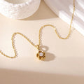HiranyaVarna Bloom Pendant Necklace lifestyle shot — 18K Gold PVD flower pendant with cubic zirconia on cream background