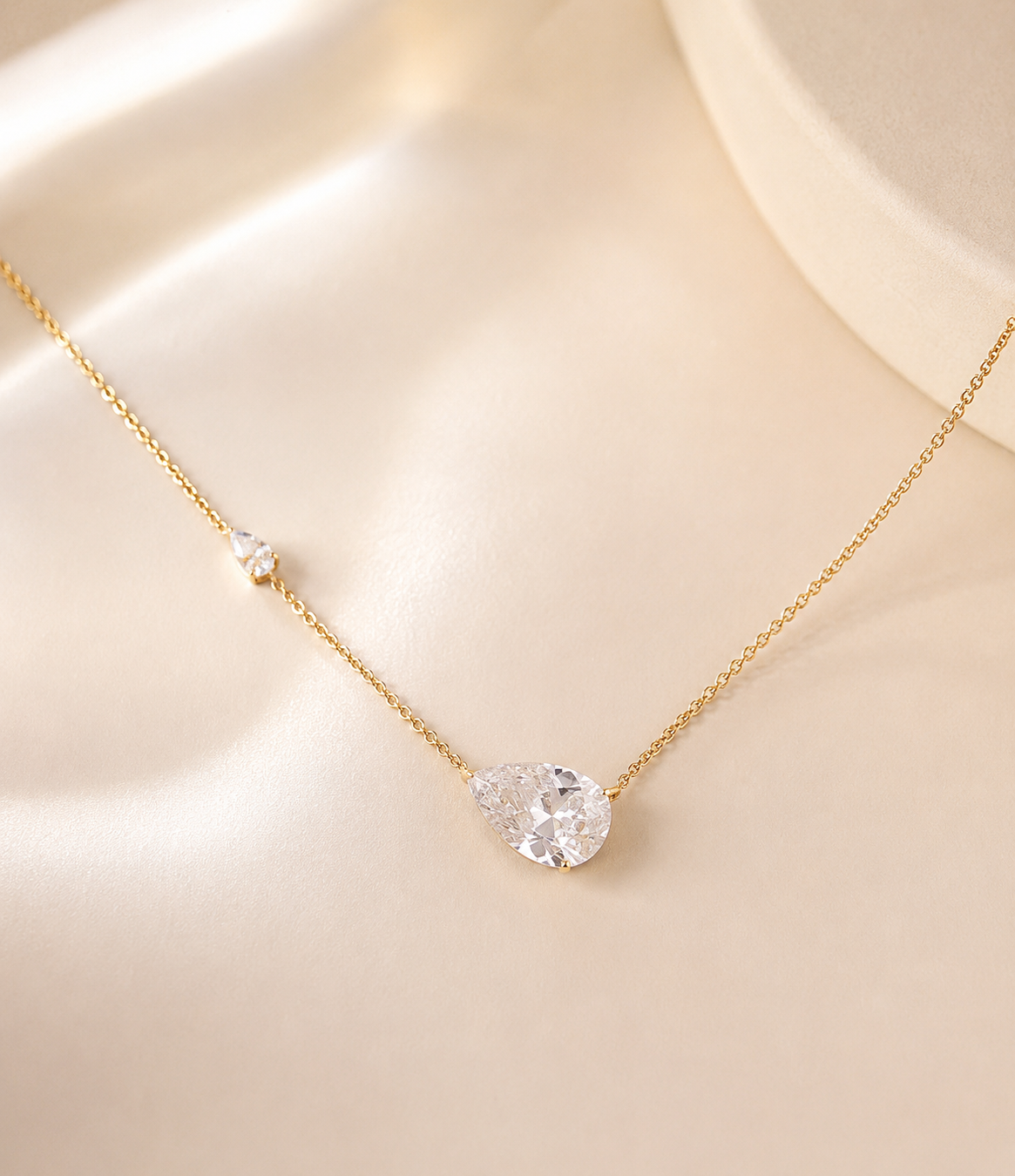 HiranyaVarna Dewdrop Pendant Necklace flat lay on ivory silk